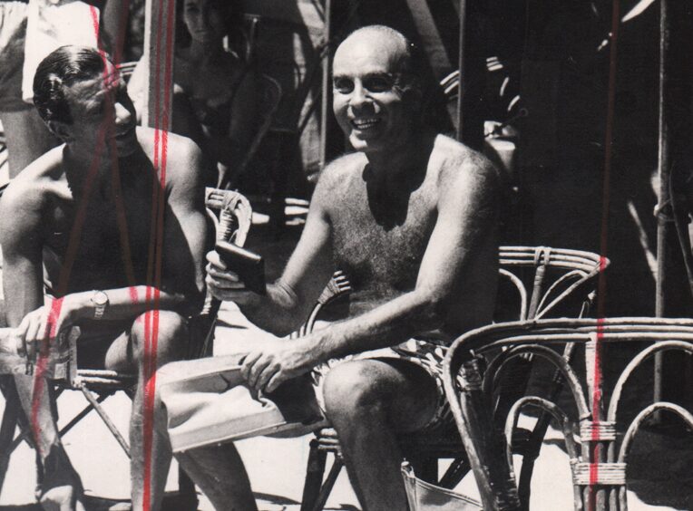 Landrú sentado en una icónica silla de mimbre marplatense. Gente, 1968.